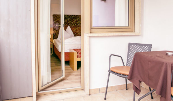 Doppel- oder Zweibettzimmer in Meran (22 m²): Hier ist das Bett das Highlight. Mit Blick ins Grüne. Ausrichtung nach Süden zur Promenade. Mit großem Balkon. ©Anguane